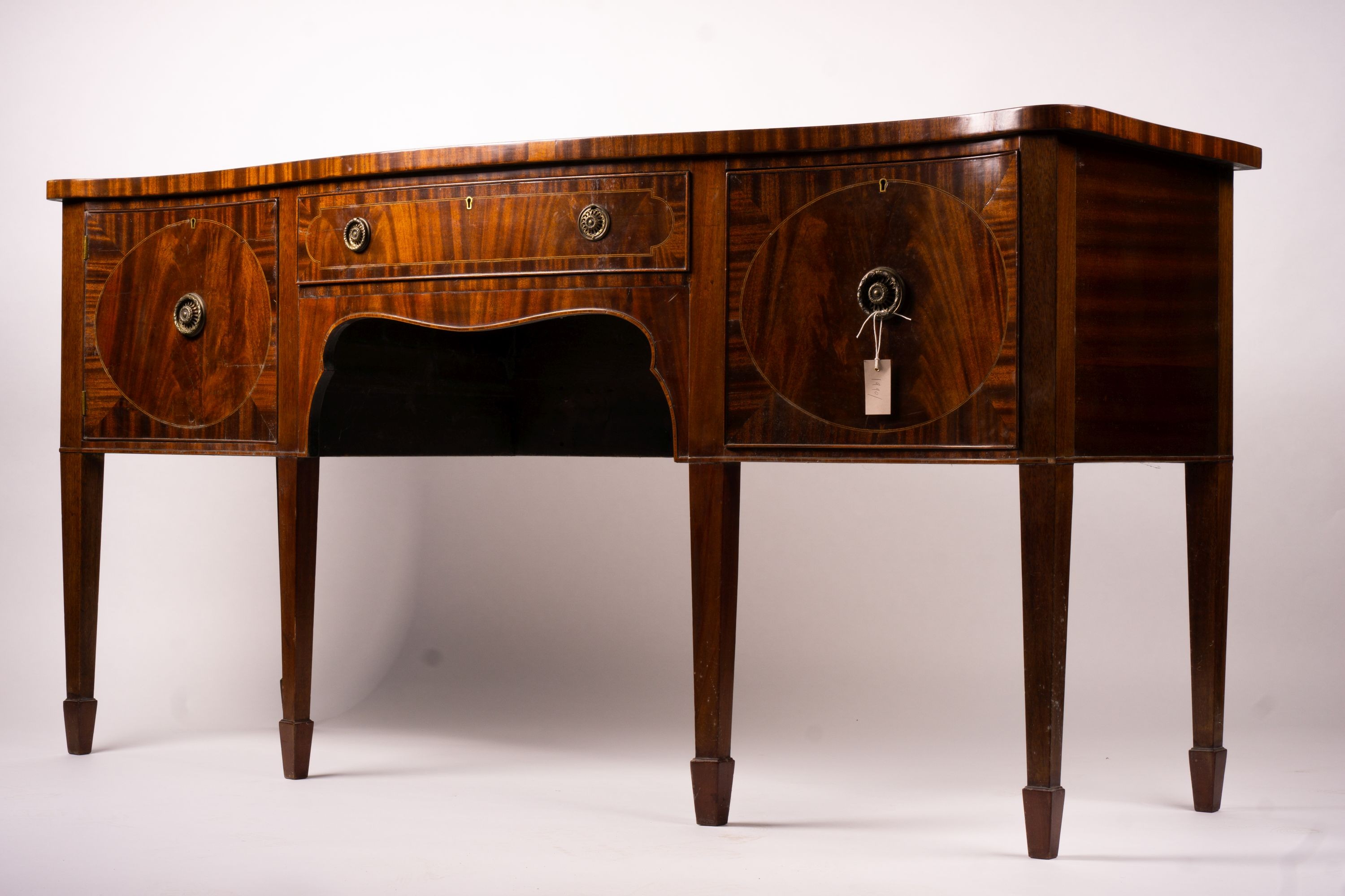 A George III style mahogany serpentine sideboard on square tapered legs, width 184cm, depth 63cm, height 93 cm